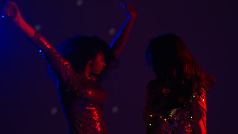 Close-Up-Of-Two-Women-In-Nightclub-Bar-Or-Disco-Dancing-With-Falling-Gold-Confetti
